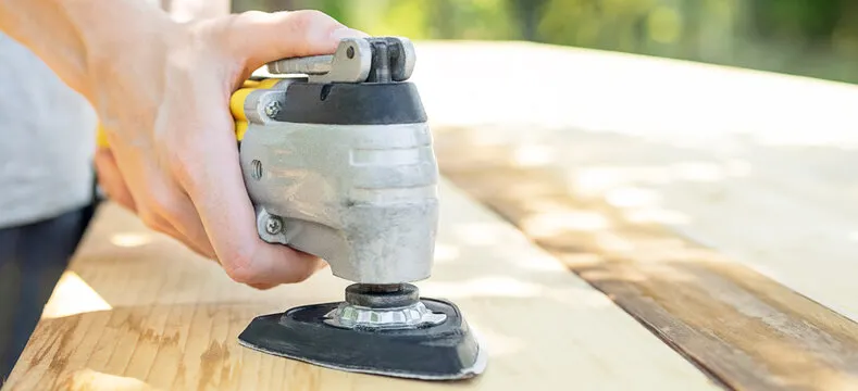Carpenter Using Oscillating Multi Tool For Sanding Wood